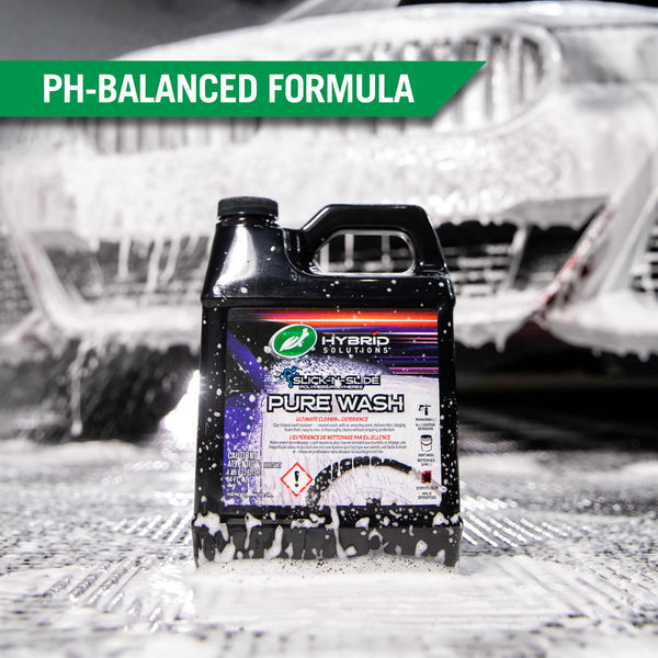 A soapy Hybrid Solutions Pure Wash is set against a backdrop of a car with thick foam covering it. 