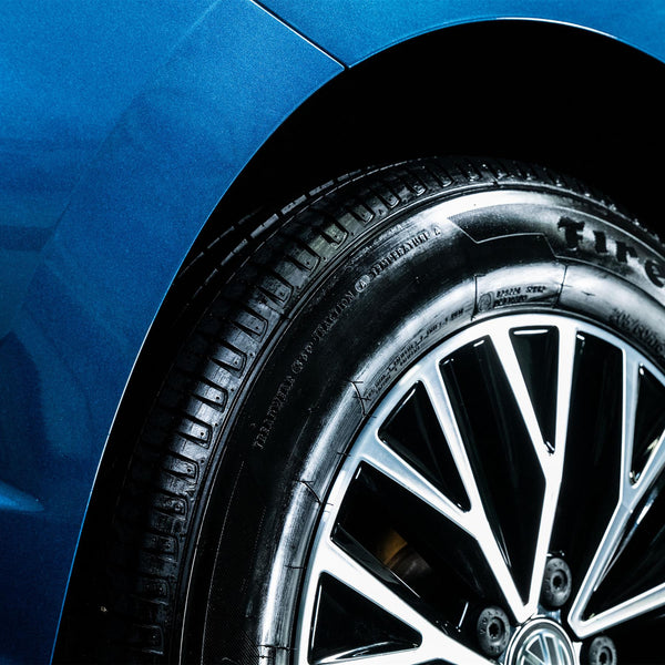 Close up of a shiny and high gloss black finish on the tire of a car. 